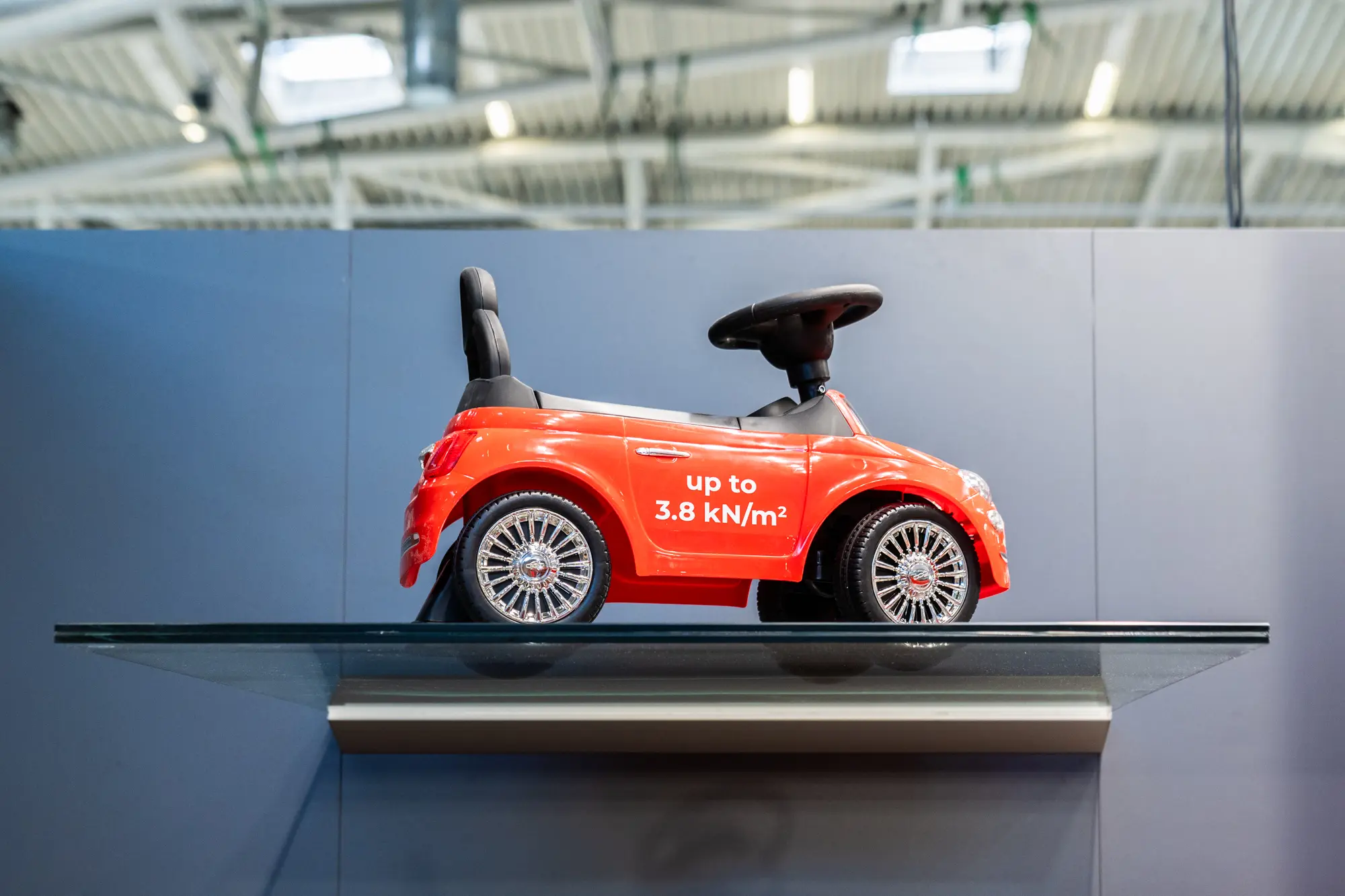 Rotes Bobbycar auf einem Glasvordach