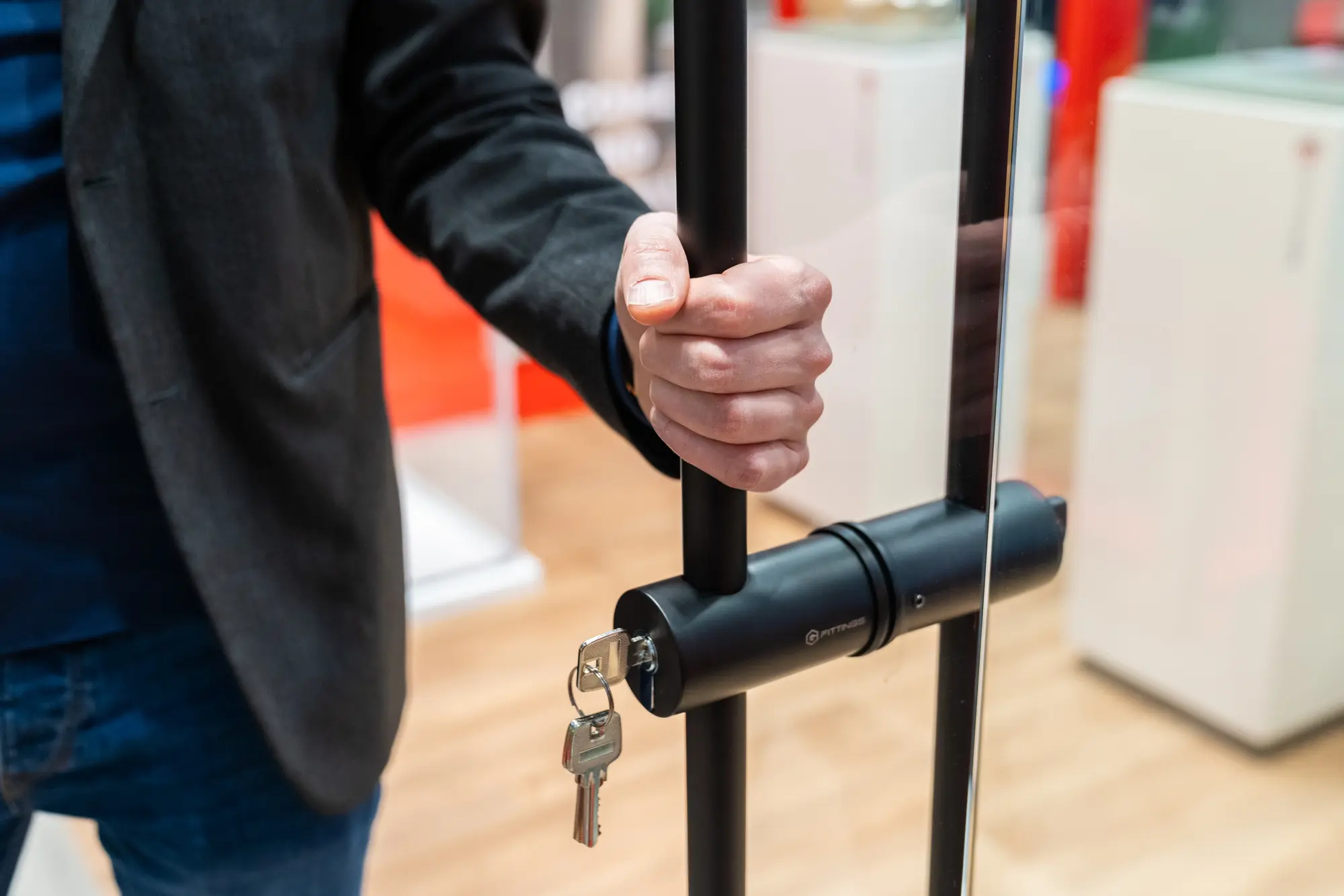 Eine Hand greift einen schwarzen Türgriff
